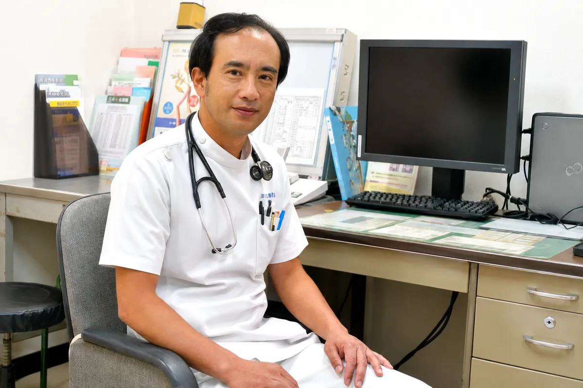診察室の椅子に腰かけた白衣の医師