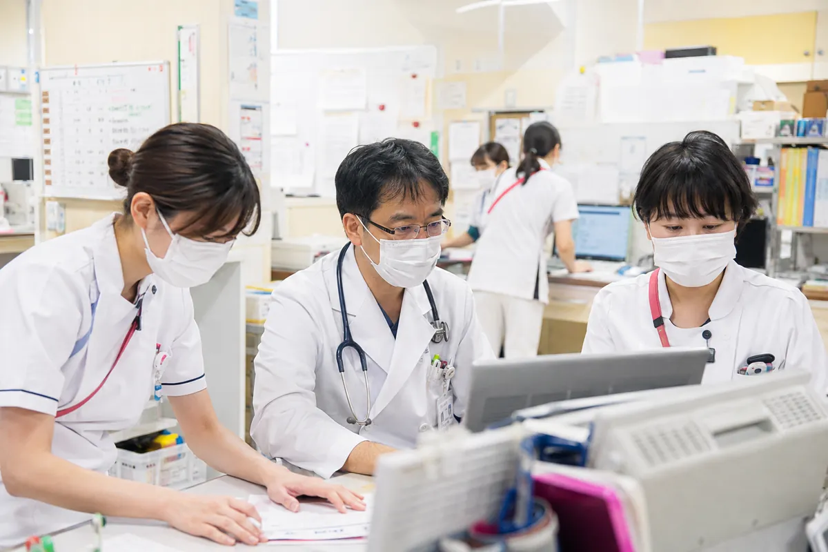 電子カルテを囲んで相談する医師と看護師