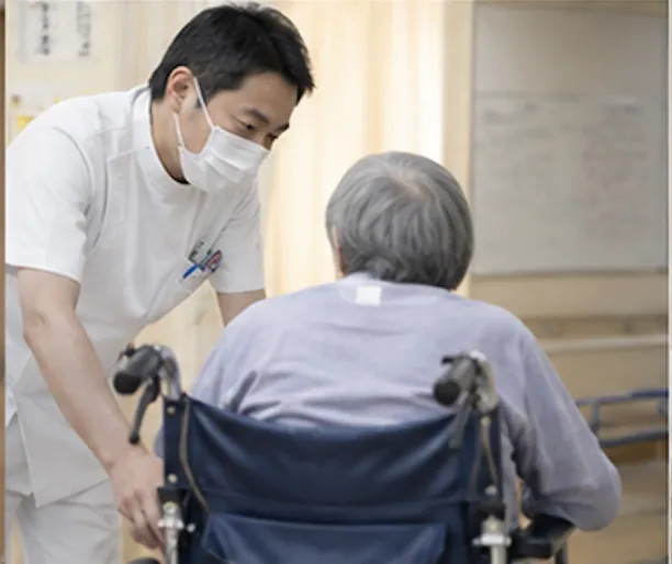 車椅子の患者さんに声をかける職員